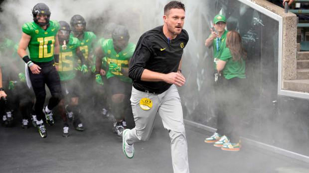 Oregon Ducks head coach Dan Lanning leads his team on the field prior to a game.